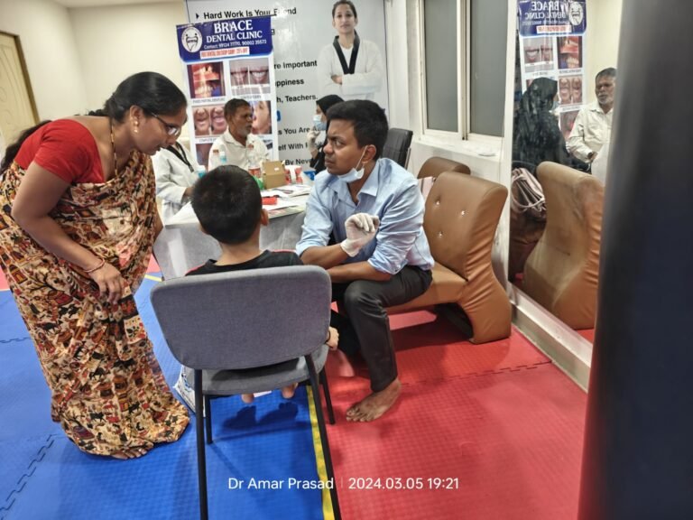 Dr G Amar Prasad doing dental examination